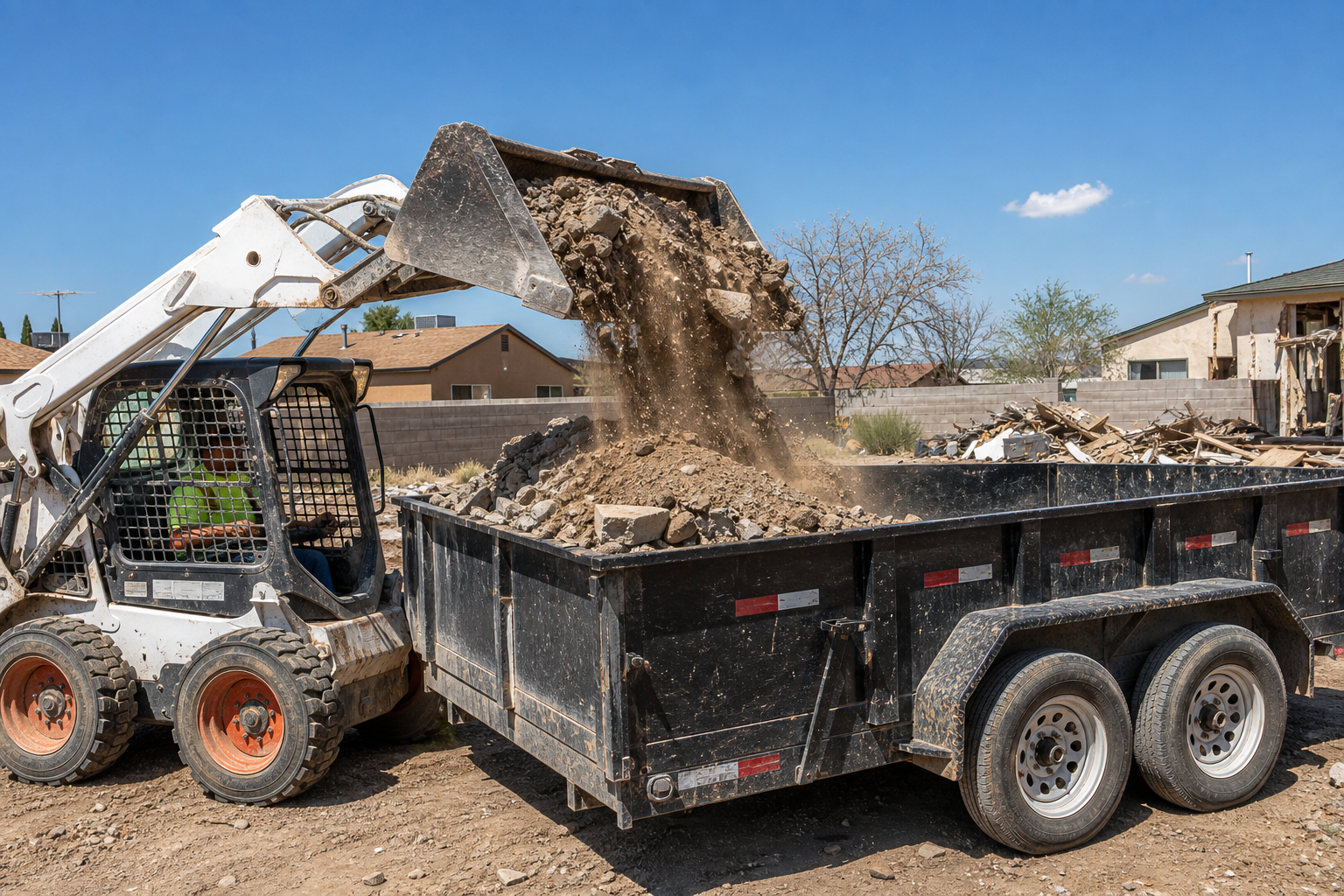 Bobcat loading dirt, gravel, and concrete into a trailer